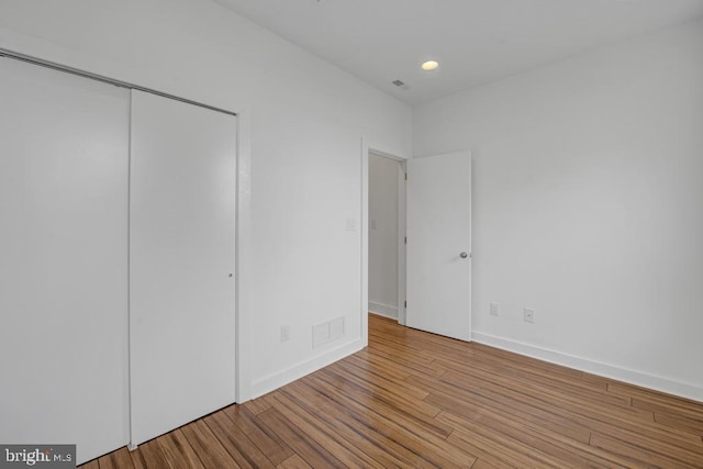 unfurnished bedroom featuring light wood-type flooring and a closet