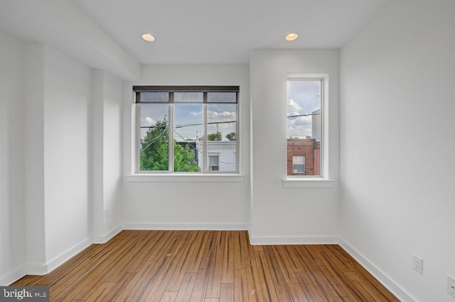 unfurnished room with hardwood / wood-style flooring and a wealth of natural light