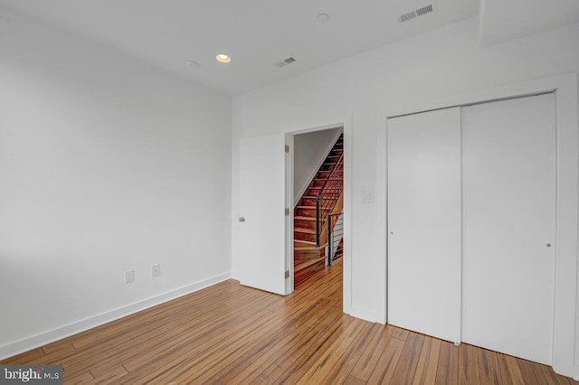 unfurnished bedroom featuring light hardwood / wood-style flooring and a closet