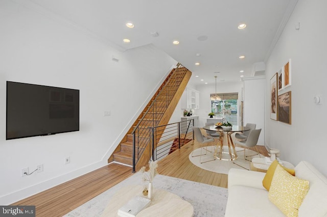 living room with light wood-type flooring and ornamental molding