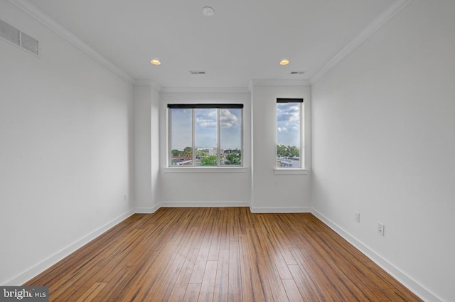 empty room with crown molding and hardwood / wood-style flooring