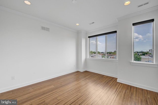 empty room featuring hardwood / wood-style floors and crown molding