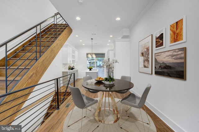 dining space featuring light hardwood / wood-style floors and ornamental molding