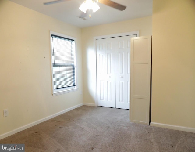 unfurnished bedroom featuring ceiling fan, light colored carpet, and a closet