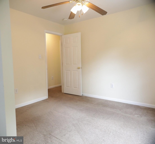 spare room with ceiling fan and light colored carpet