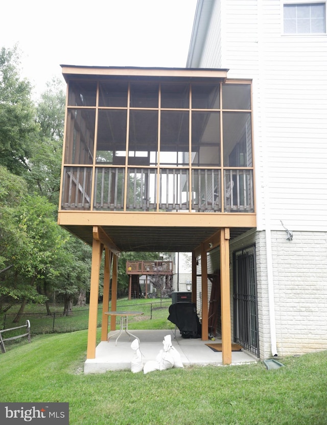 rear view of property with a sunroom and a yard