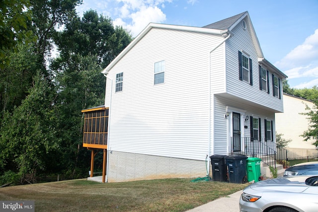 view of home's exterior with a yard and a sunroom