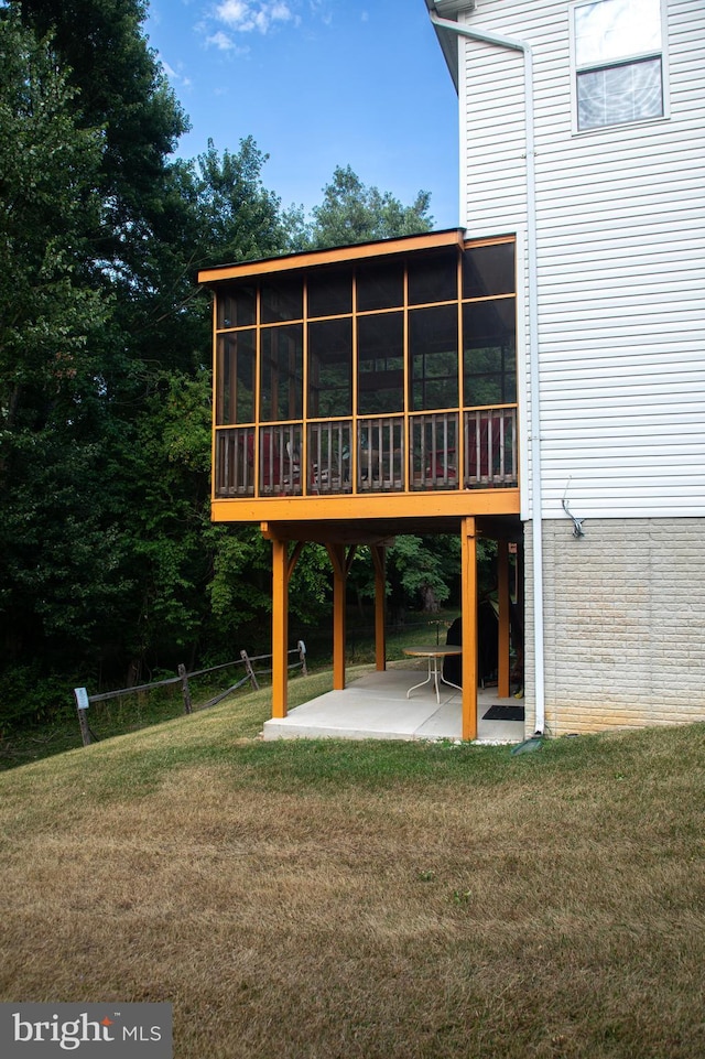 rear view of property featuring a sunroom, a yard, and a patio