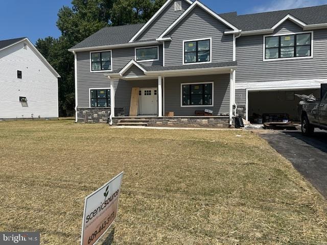 view of front facade featuring a front lawn, a porch, and a garage