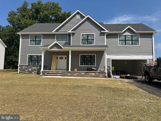 view of front of house with a garage, a front lawn, and a porch