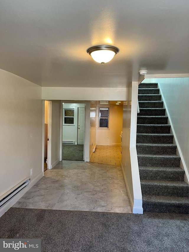 stairway featuring baseboard heating and carpet