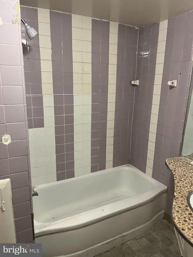 bathroom featuring tile patterned floors, tiled shower / bath combo, and vanity