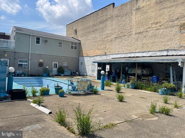 rear view of house featuring a pool