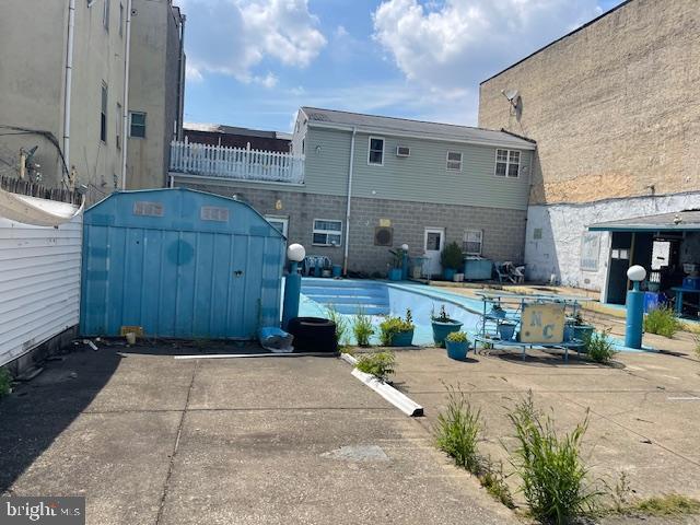 exterior space with a shed, a swimming pool, and fence