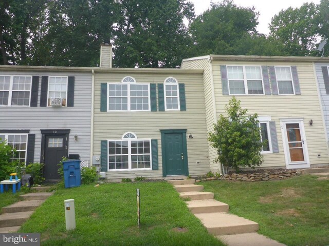 view of front of house with cooling unit and a front lawn