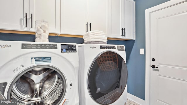 laundry room with washer and clothes dryer and cabinets