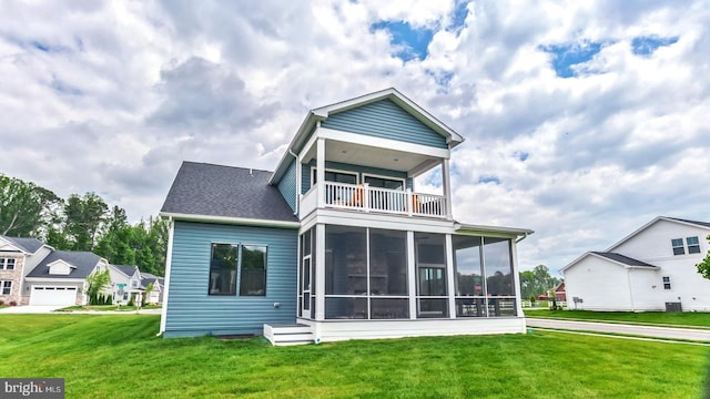 rear view of house featuring a garage, a balcony, a sunroom, and a yard