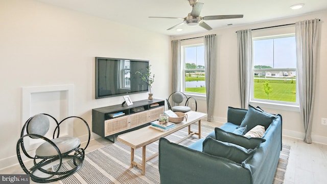 living room featuring light hardwood / wood-style floors and ceiling fan