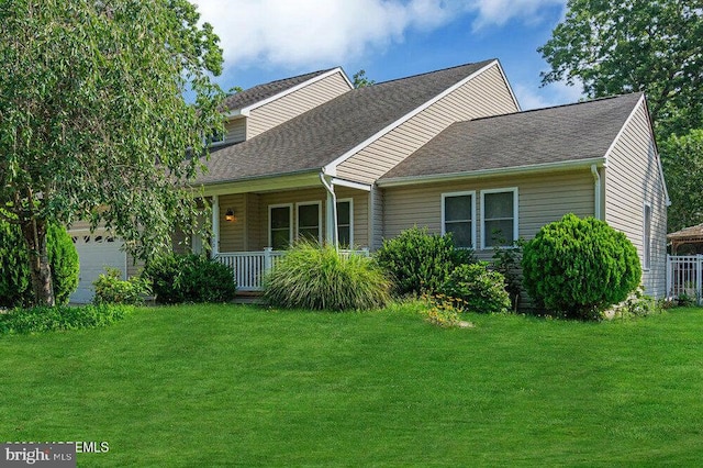 view of front of property featuring a garage, a porch, and a front yard