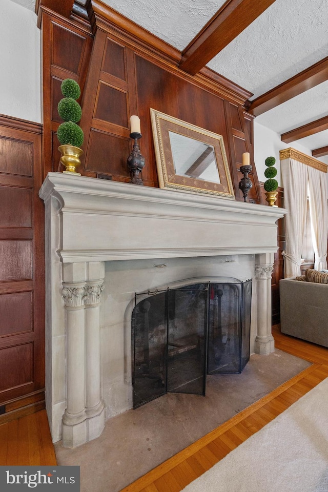 interior details with beam ceiling, hardwood / wood-style floors, and a textured ceiling