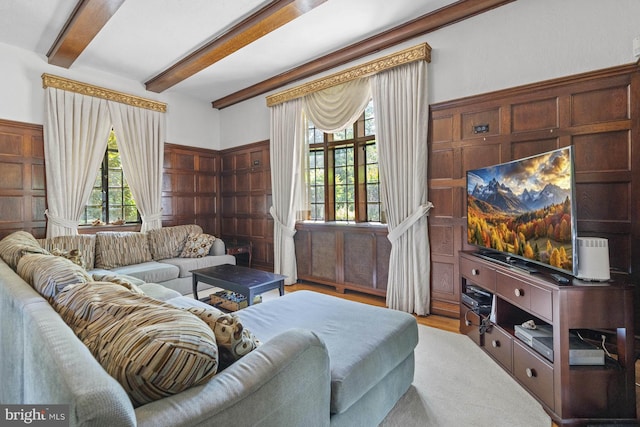 living room with beamed ceiling, a wealth of natural light, and light hardwood / wood-style flooring