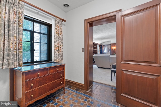 hall with a textured ceiling