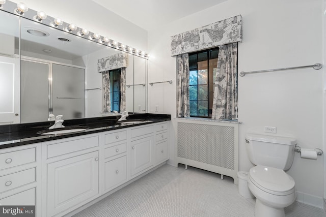 bathroom featuring walk in shower, toilet, radiator heating unit, vanity, and tile patterned flooring