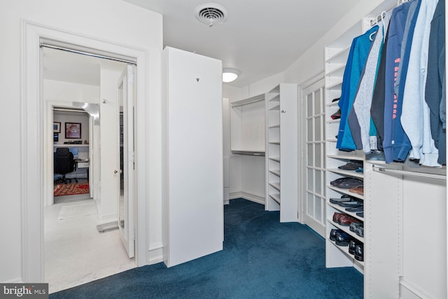 spacious closet with dark carpet