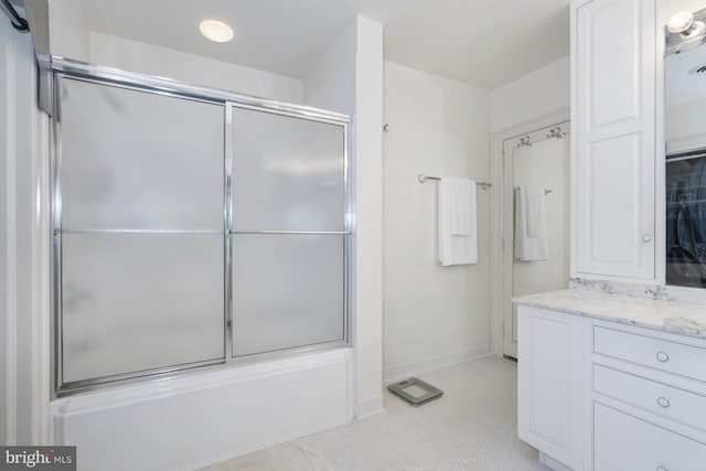 bathroom featuring enclosed tub / shower combo, vanity, and tile patterned floors