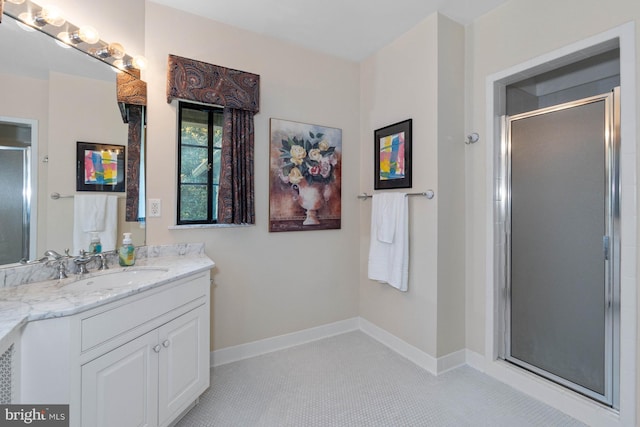 bathroom with tile patterned flooring, vanity, and walk in shower