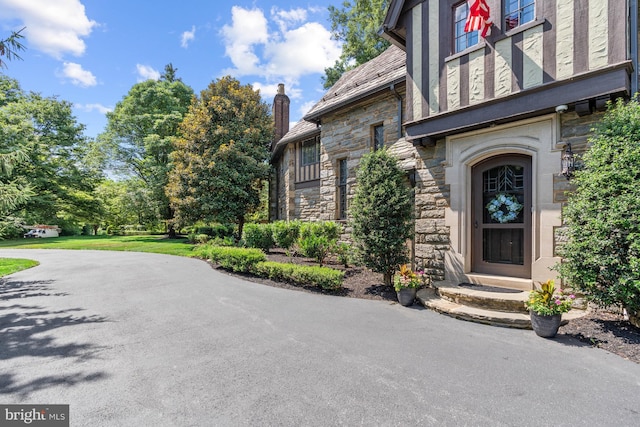 entrance to property with a lawn