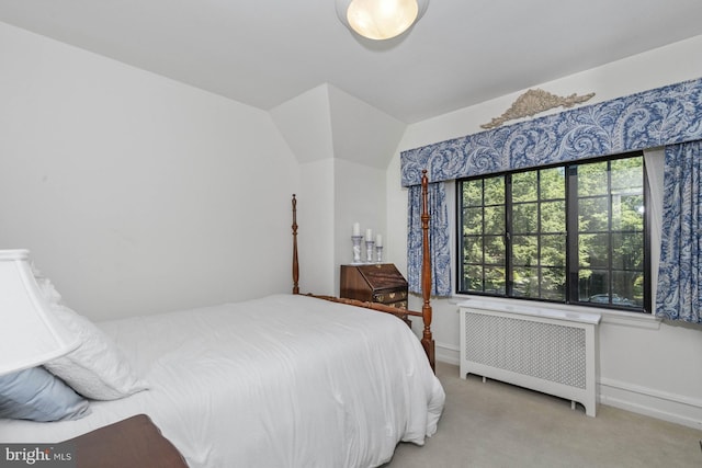 bedroom with radiator heating unit and light carpet