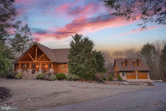 log home featuring a porch and a garage