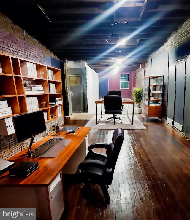 home office featuring brick wall and hardwood / wood-style flooring