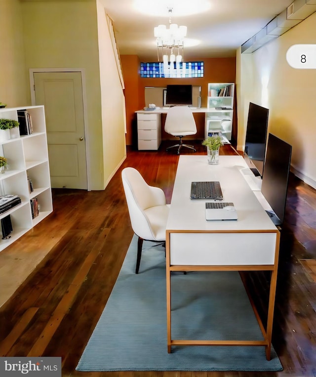 office with dark hardwood / wood-style flooring and an inviting chandelier