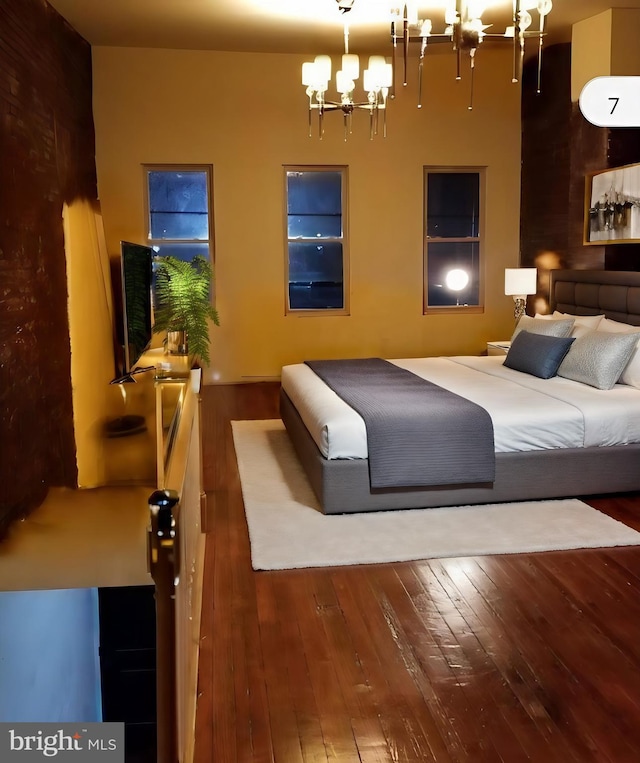 bedroom featuring a notable chandelier and hardwood / wood-style flooring