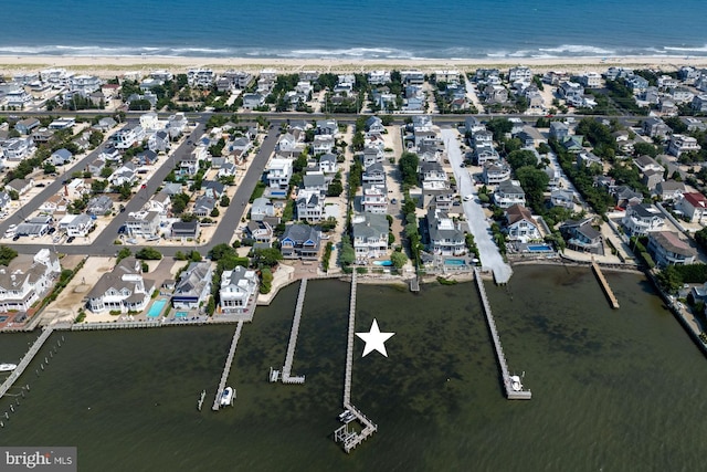 bird's eye view with a residential view, a water view, and a beach view