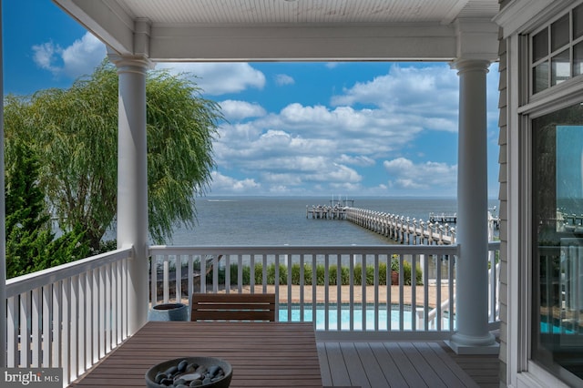 deck featuring a water view and an outdoor pool