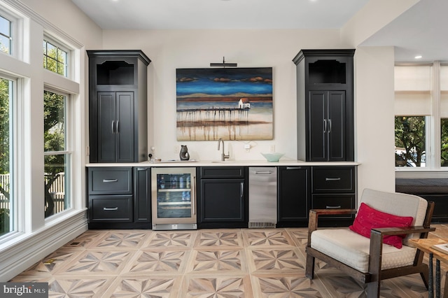 bar with a sink, fridge, wine cooler, and indoor wet bar