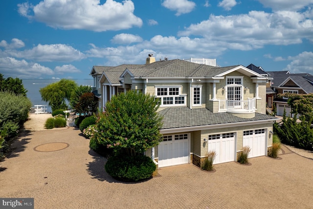 view of front of house featuring a balcony, a garage, and decorative driveway