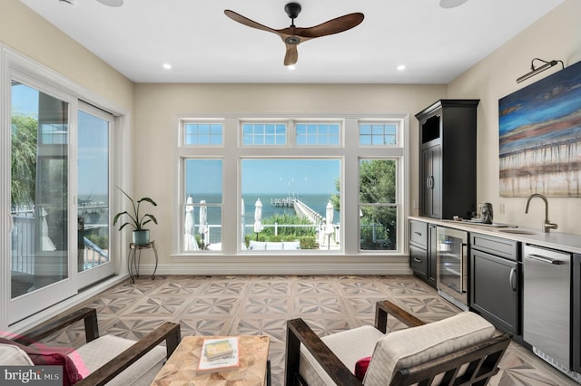 interior space with indoor wet bar, light floors, recessed lighting, ceiling fan, and beverage cooler