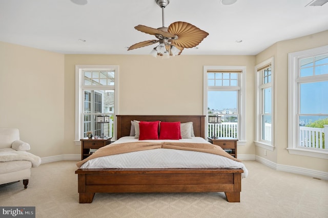 bedroom with light carpet, visible vents, baseboards, and a ceiling fan