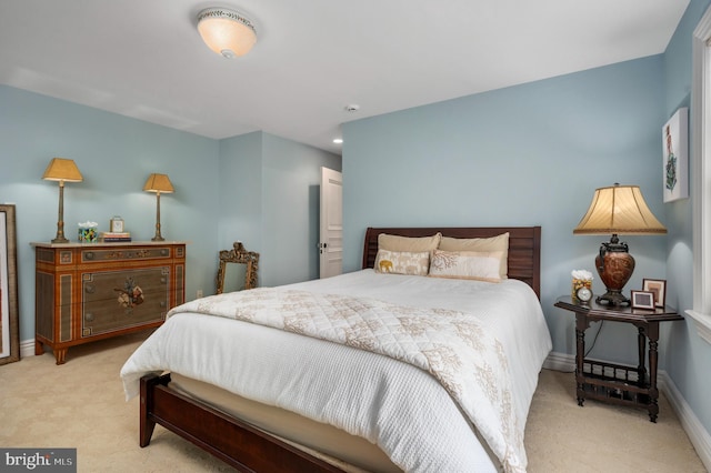 bedroom with baseboards and light colored carpet