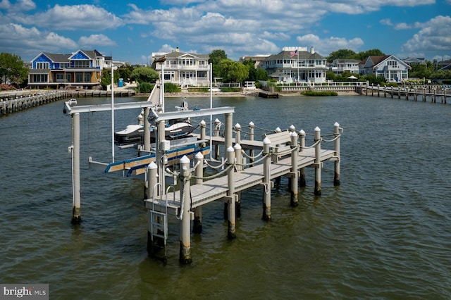 view of dock with a water view, boat lift, and a residential view