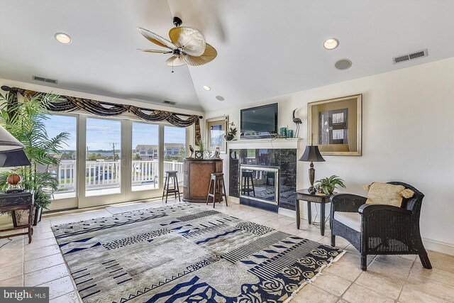 living room featuring light carpet, ceiling fan with notable chandelier, and lofted ceiling