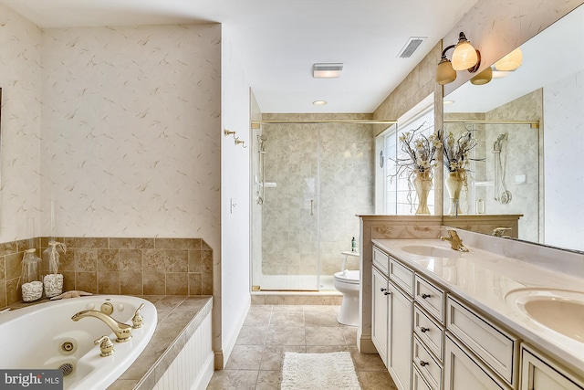 bathroom featuring double vanity, a tub with jets, a sink, and visible vents