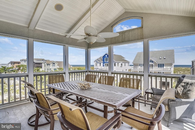 sunroom / solarium featuring a wealth of natural light, a residential view, a water view, and lofted ceiling with beams