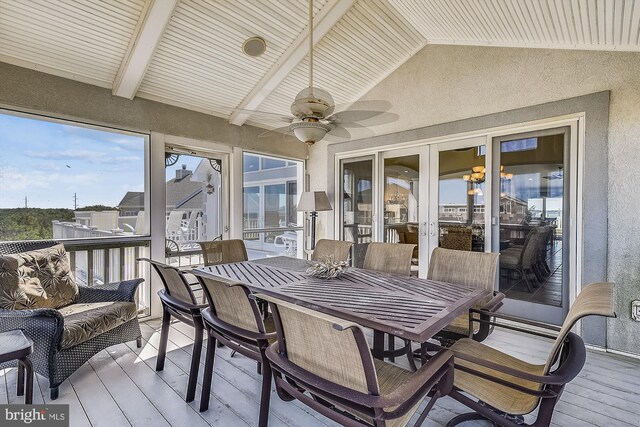 sunroom / solarium with a water view, vaulted ceiling with beams, and ceiling fan