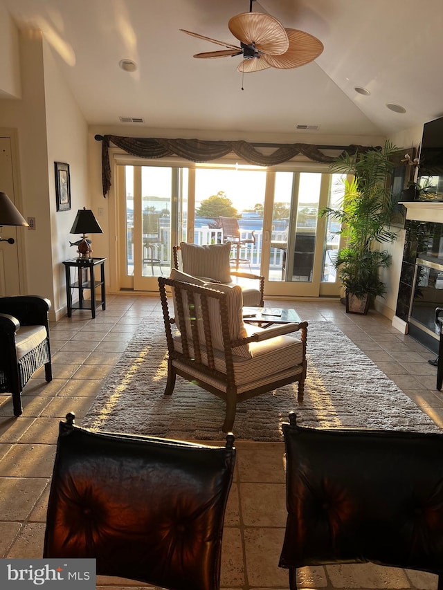 sunroom / solarium featuring lofted ceiling, ceiling fan, a fireplace, and a healthy amount of sunlight