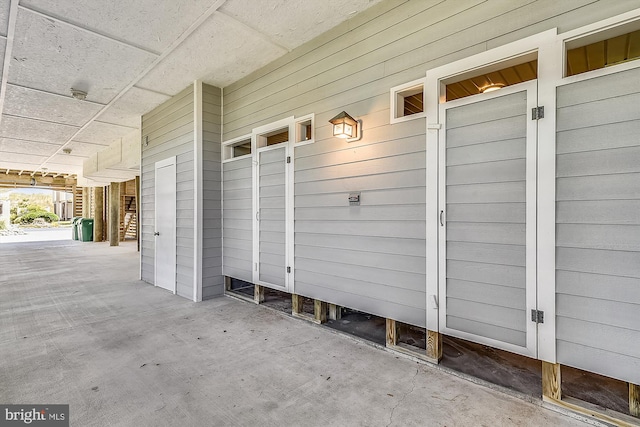 mudroom with wooden walls and concrete flooring